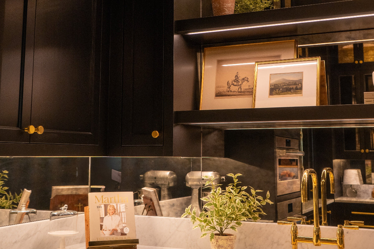 Modern pantry with dark cabinets, a sink, and decorative elements, including LED strip lights illuminating the under cabinet.