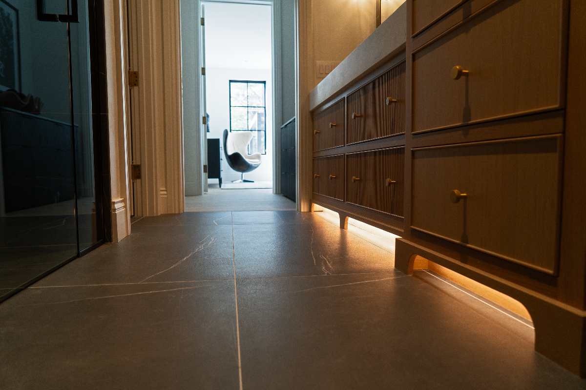 Bathroom showing cabinets under sink and warm toe kick lighting underneath the cabinets