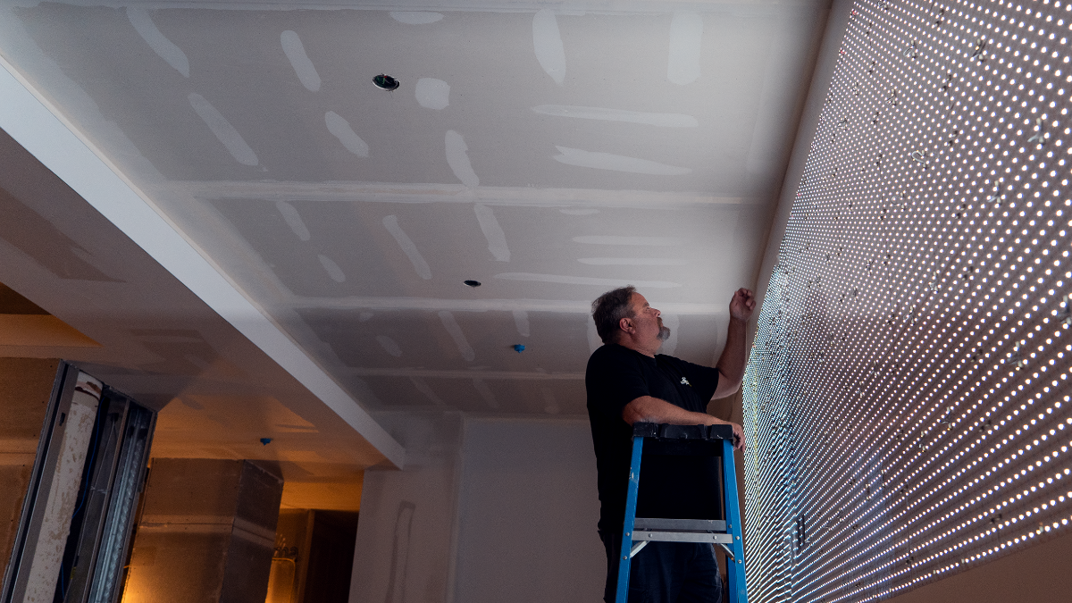 Person on a ladder working on a ceiling installation.