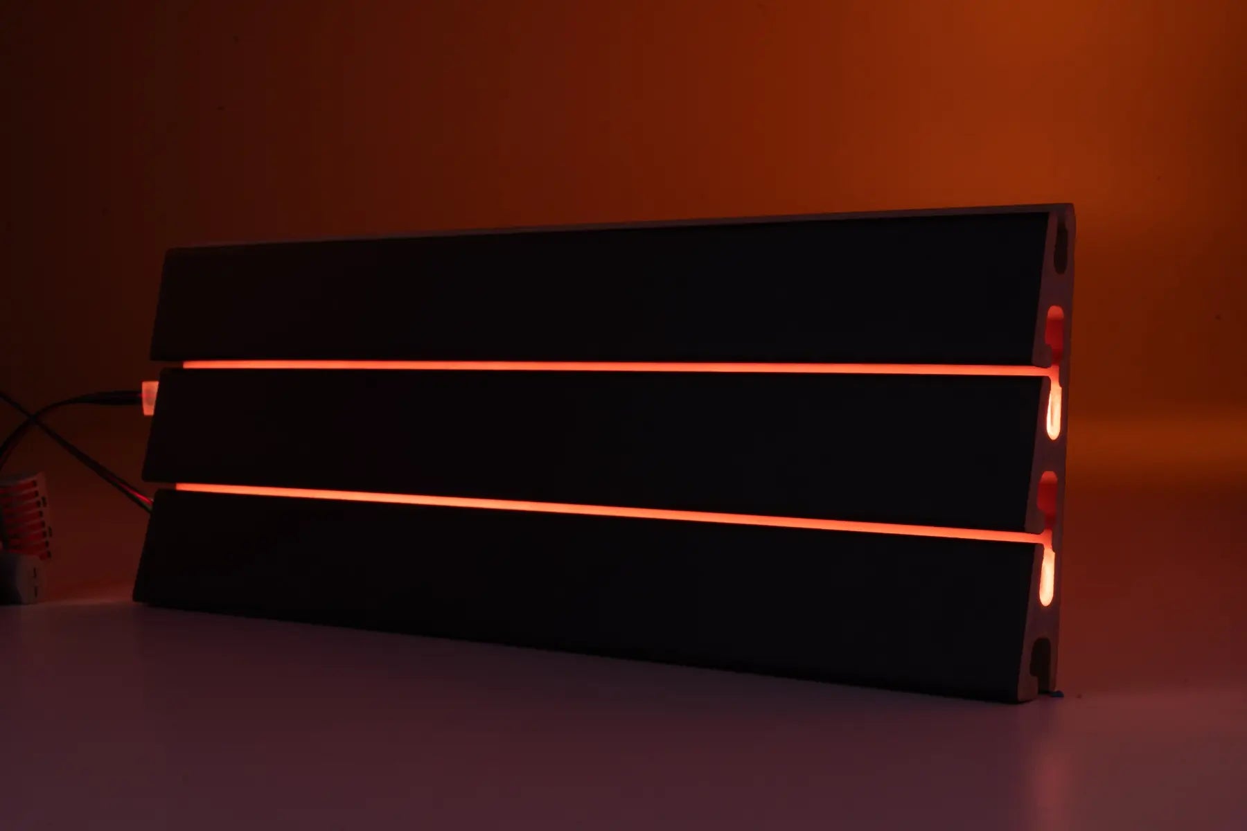 Black Tile being lit up by LED strip light on a dark background