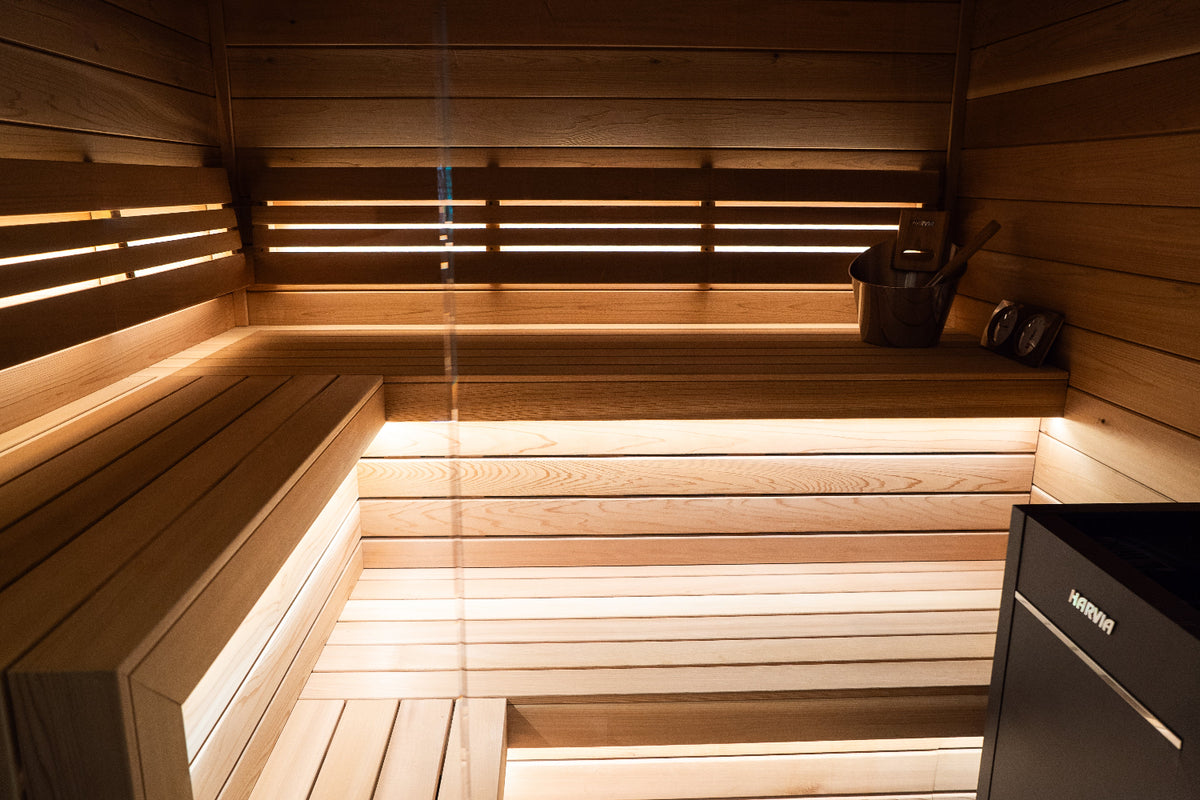 Wooden sauna interior with benches and a heater.
