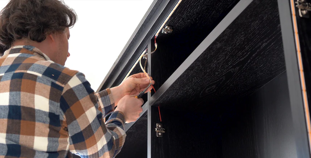 Electrician crimping wires on LED strip light