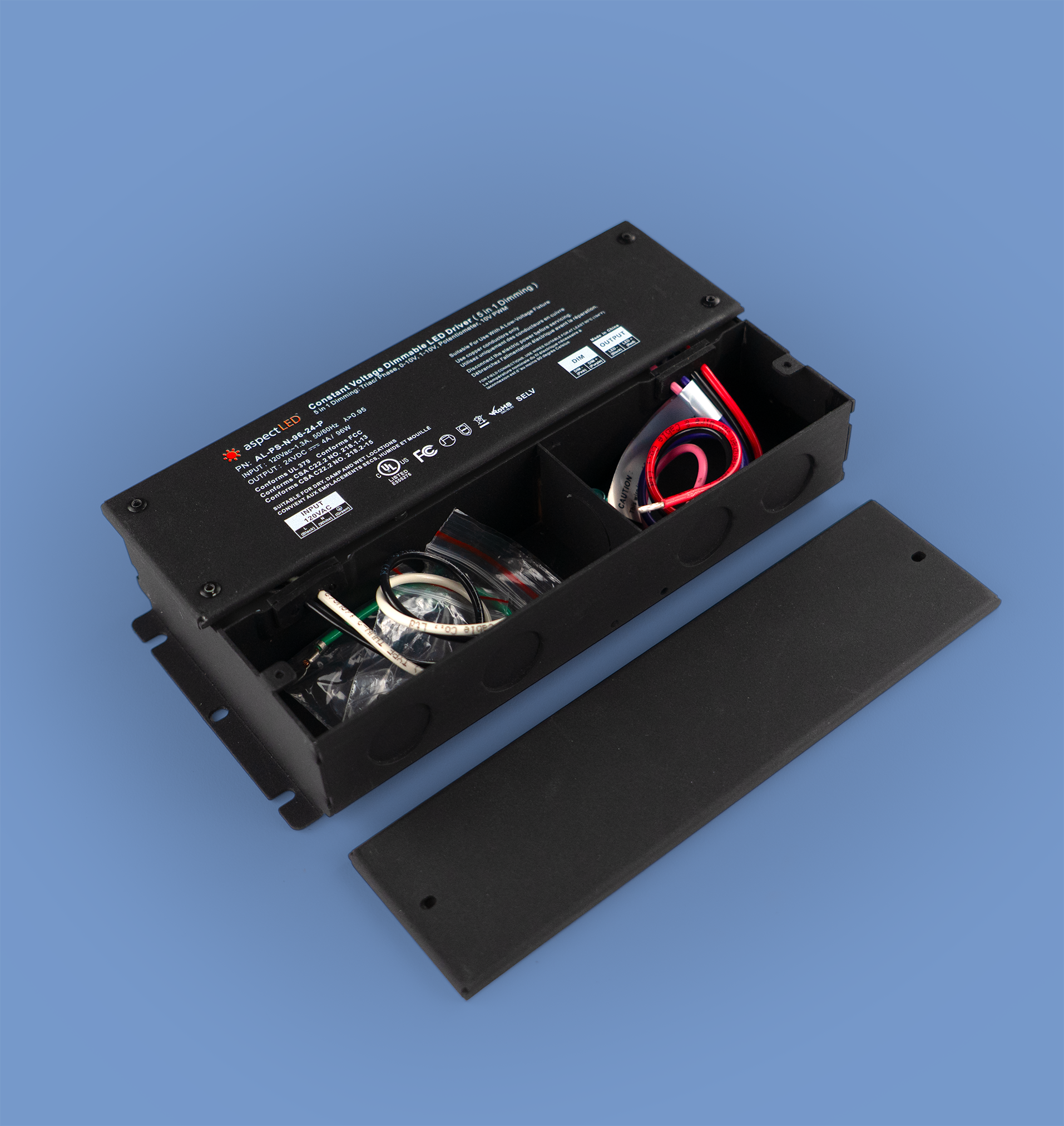 A black metal LED driver power supply shown open, with its lid placed beside it on a solid blue background. The interior compartments contain various cables and internal components.