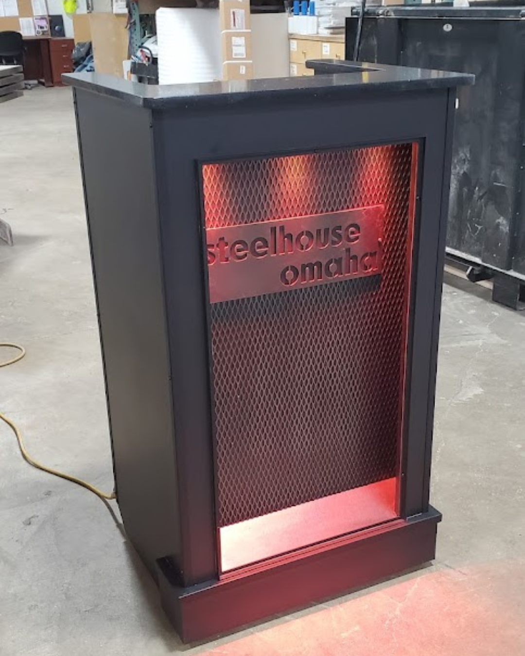 Black and red metal cabinet with 'steelhouse omaha' branding backlit by strip lights
