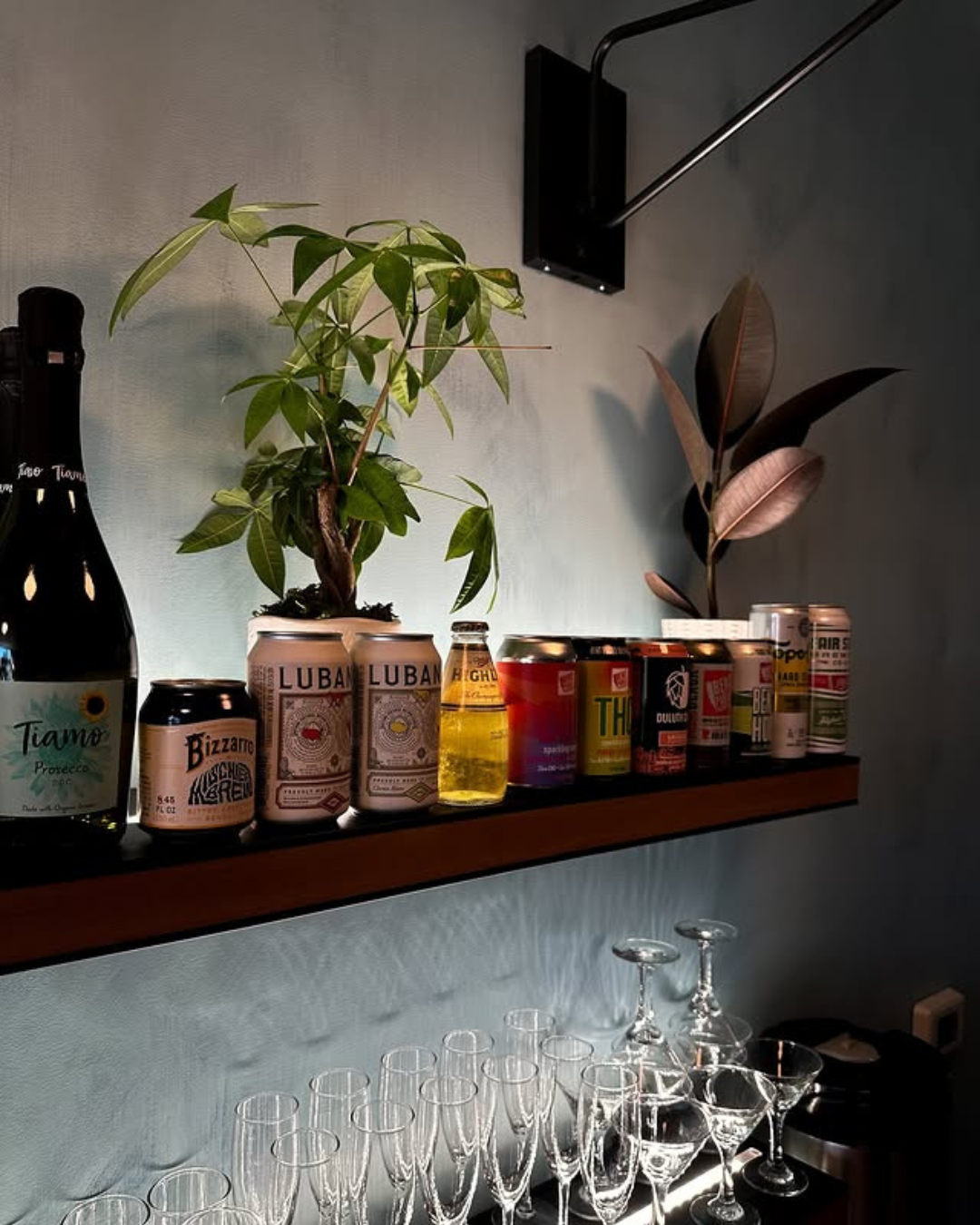 Alcohol bottles and cans on a shelf with strip lights backlighting them