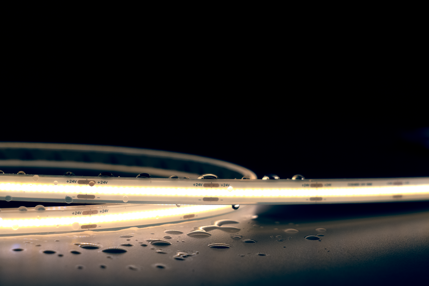 Close-up of a strip light with water droplets on a dark background
