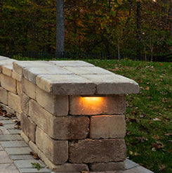 Stone outdoor seating area with built-in lighting in a garden setting