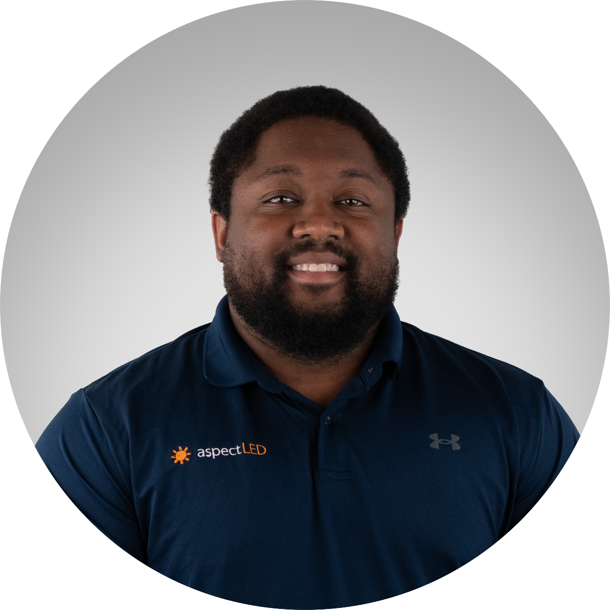 Man wearing a navy blue shirt with aspectLED logo on a gray background